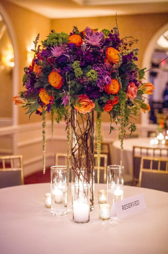 Orange and purple wedding flowers table arrangement